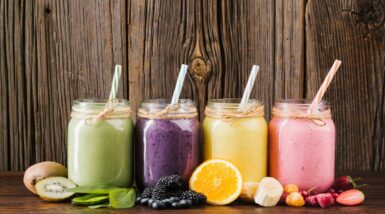 alimentos-composicao-colorida-de-frutas-e-smoothies-em-fundo-de-madeira